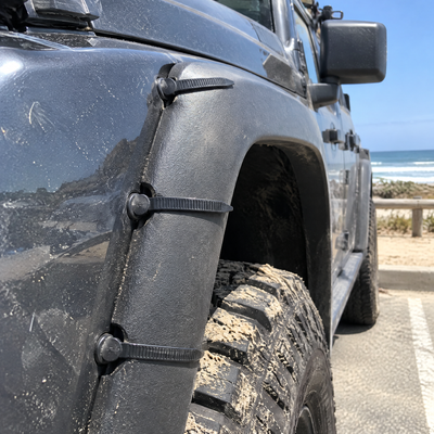 Fender flare fixed with three ties at a beach parking lot