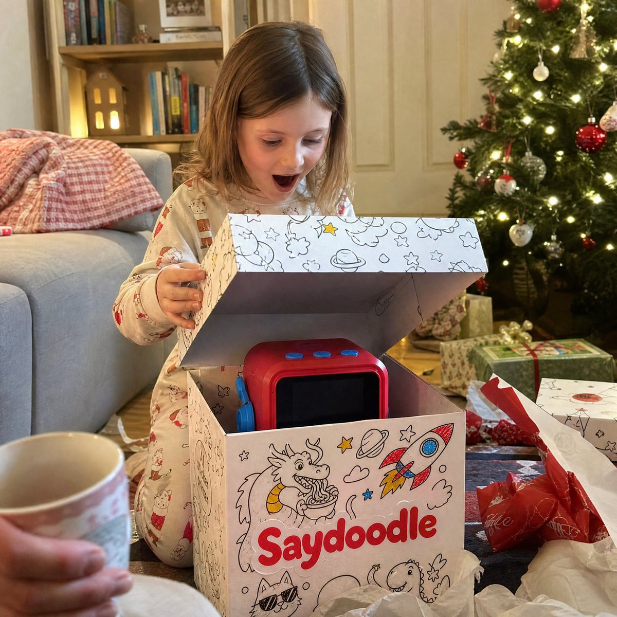 A girl opening a Saydoodle box on Christmas morning