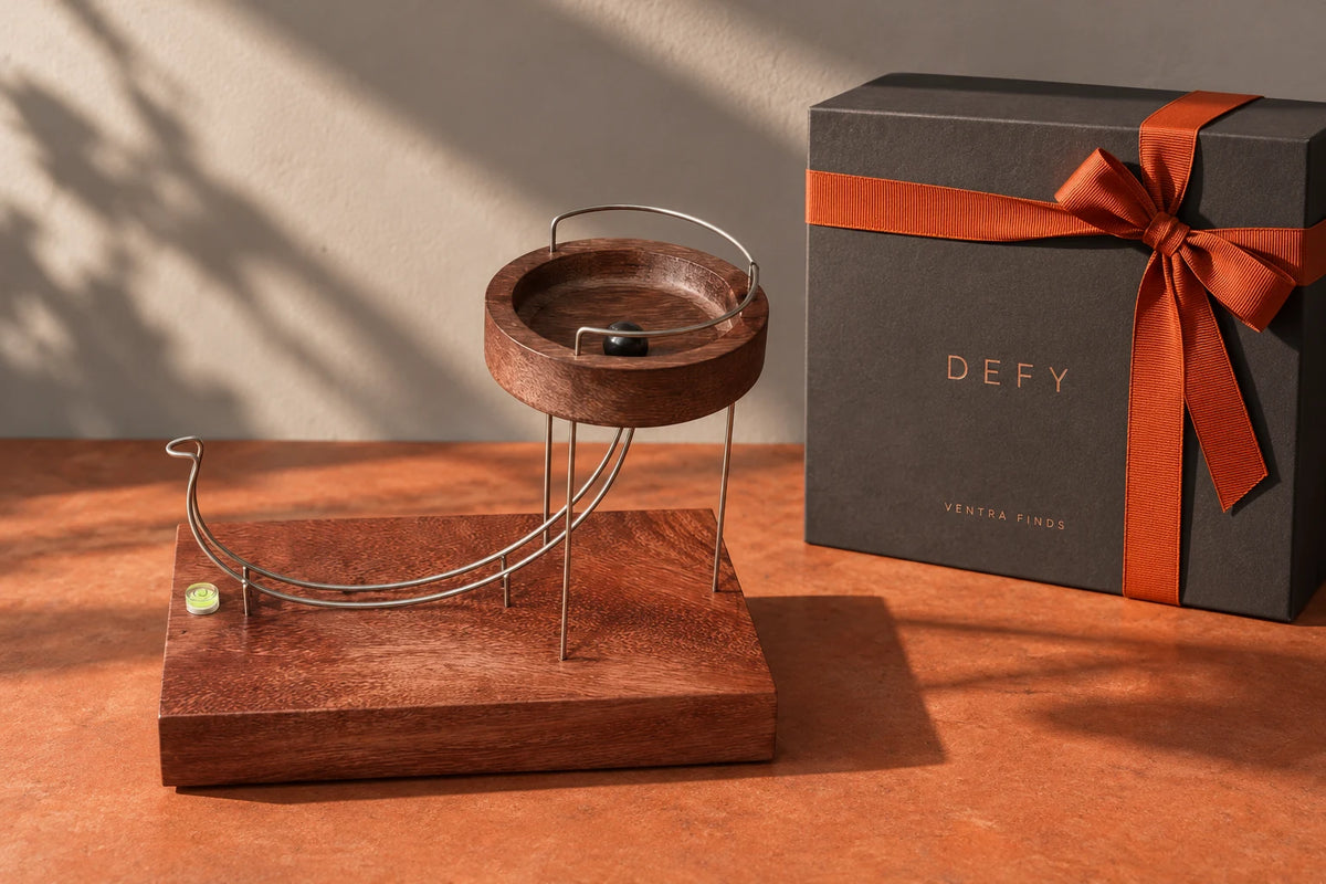 DEFY wooden kinetic sculpture beside its charcoal presentation box