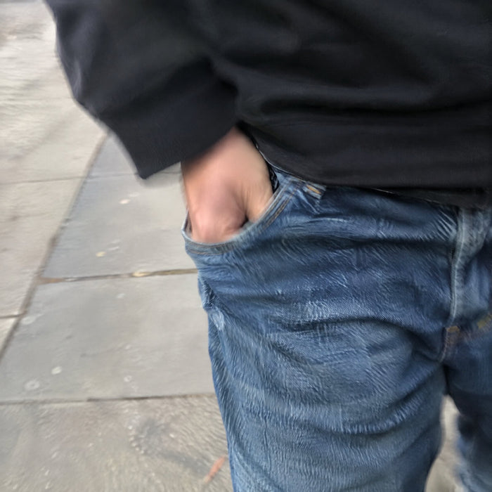 Hand reaching into a jeans pocket