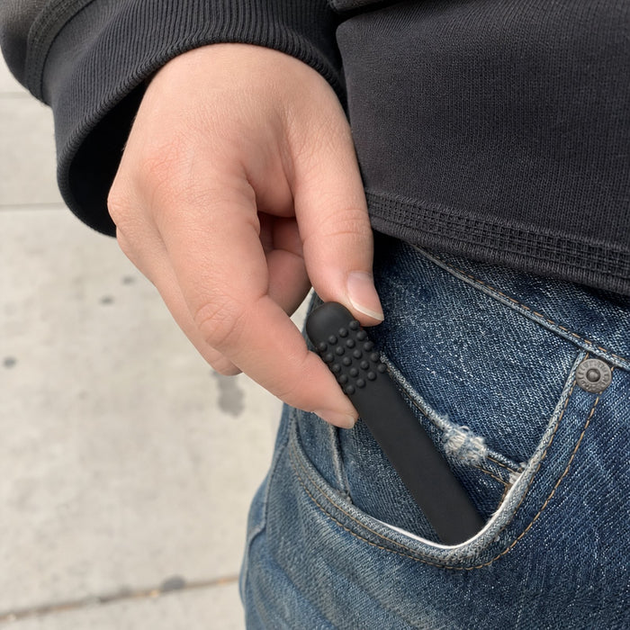 Hand pulling a black Cola FreeAir out of a jeans pocket