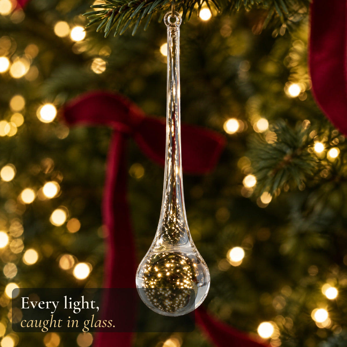 A clear glass drop holding a sphere of golden tree lights