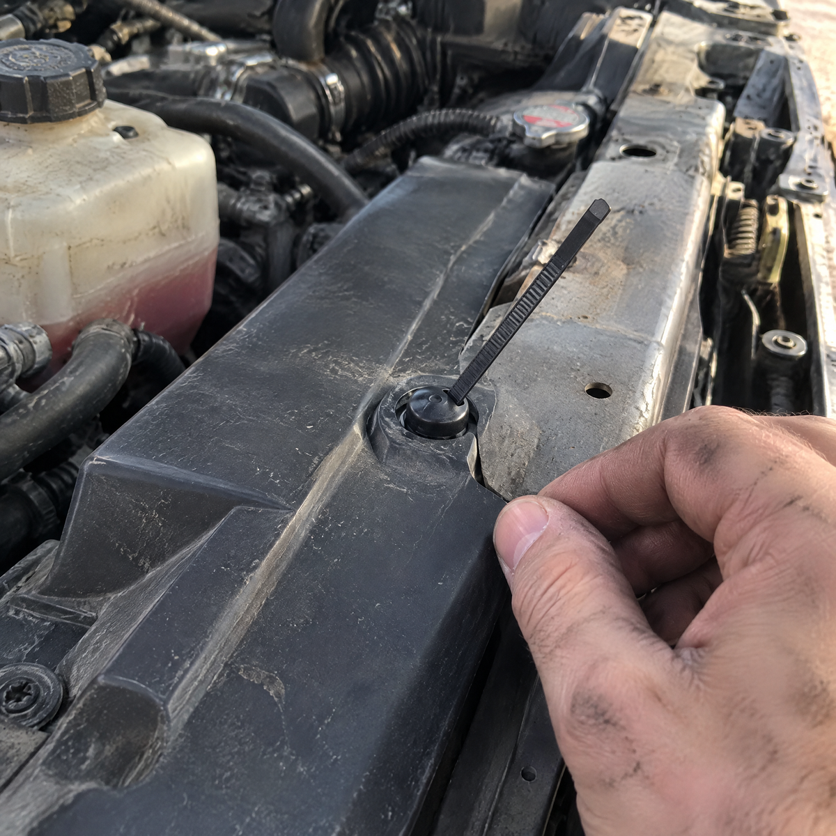 Securing a radiator shroud in the engine bay