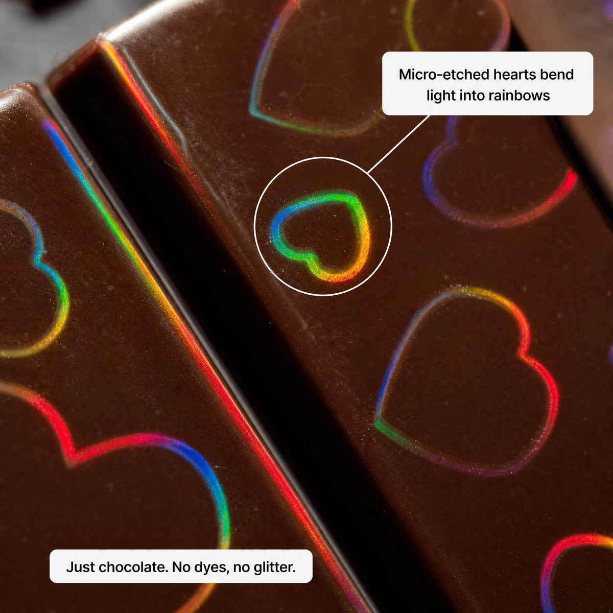 Macro of the chocolate surface: micro-etched hearts bend light into rainbows. Just chocolate, no dyes, no glitter