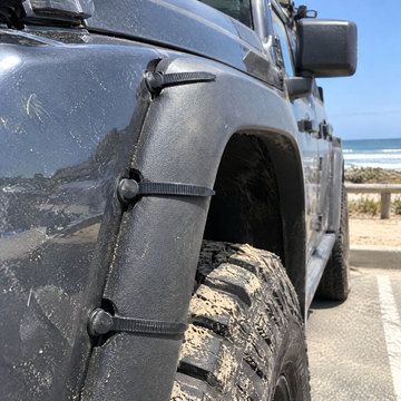 Fender flare fixed with three ties at a beach parking lot