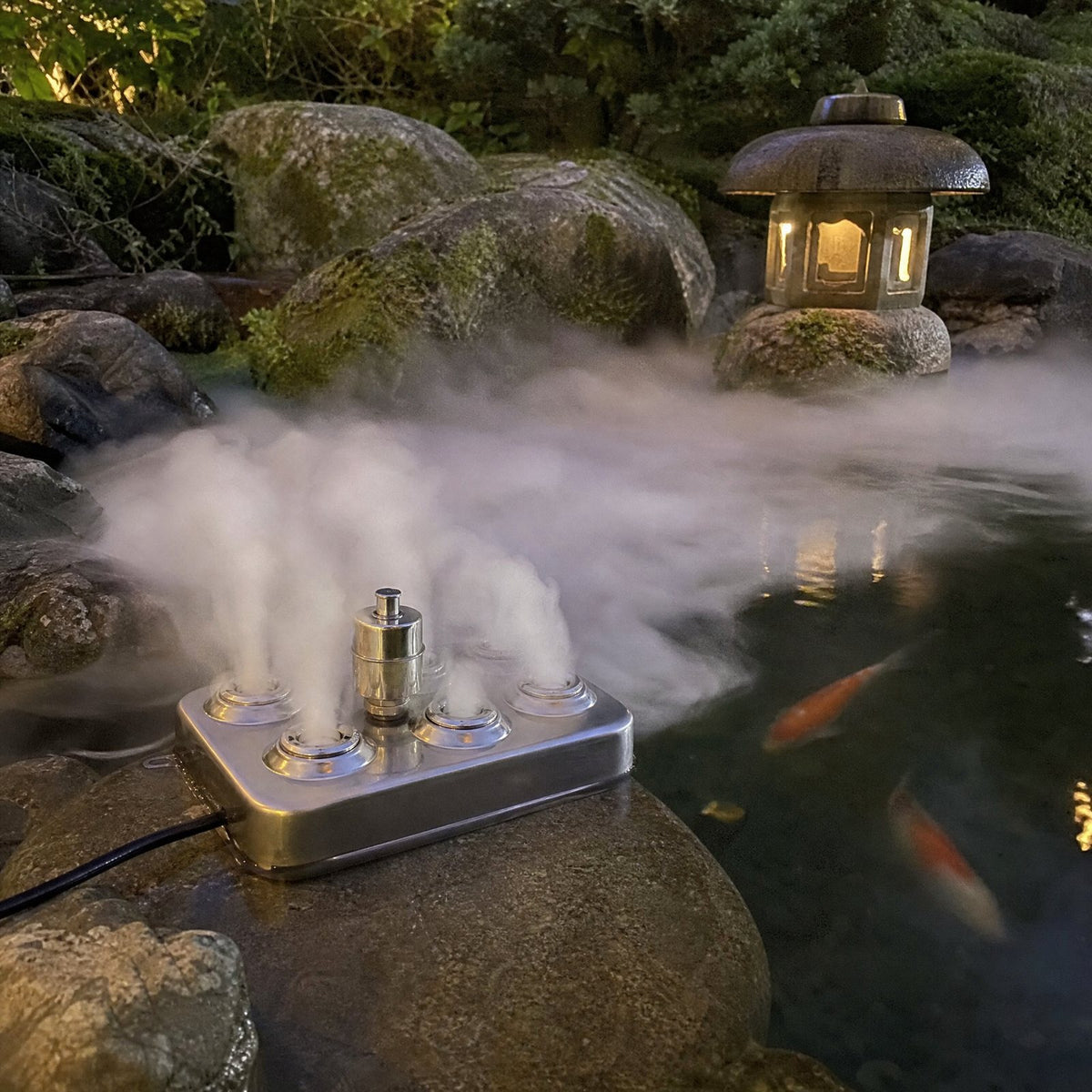 Fogger at the edge of a koi pond pushing fog across the water