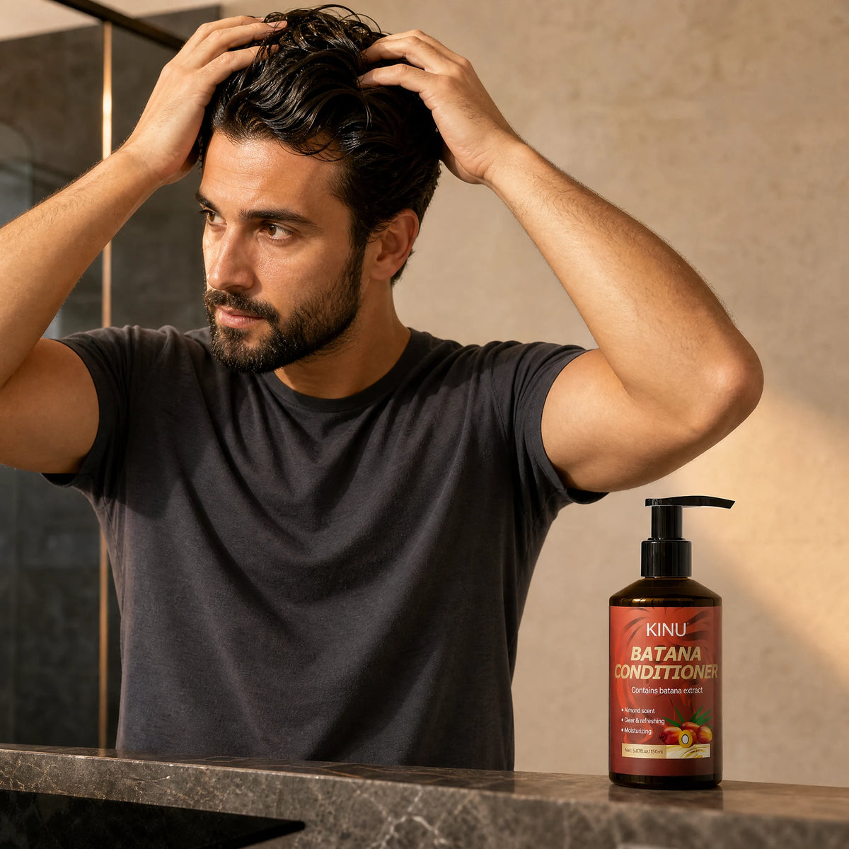 An adult man working conditioner through his damp head hair, with KINU conditioner on the counter