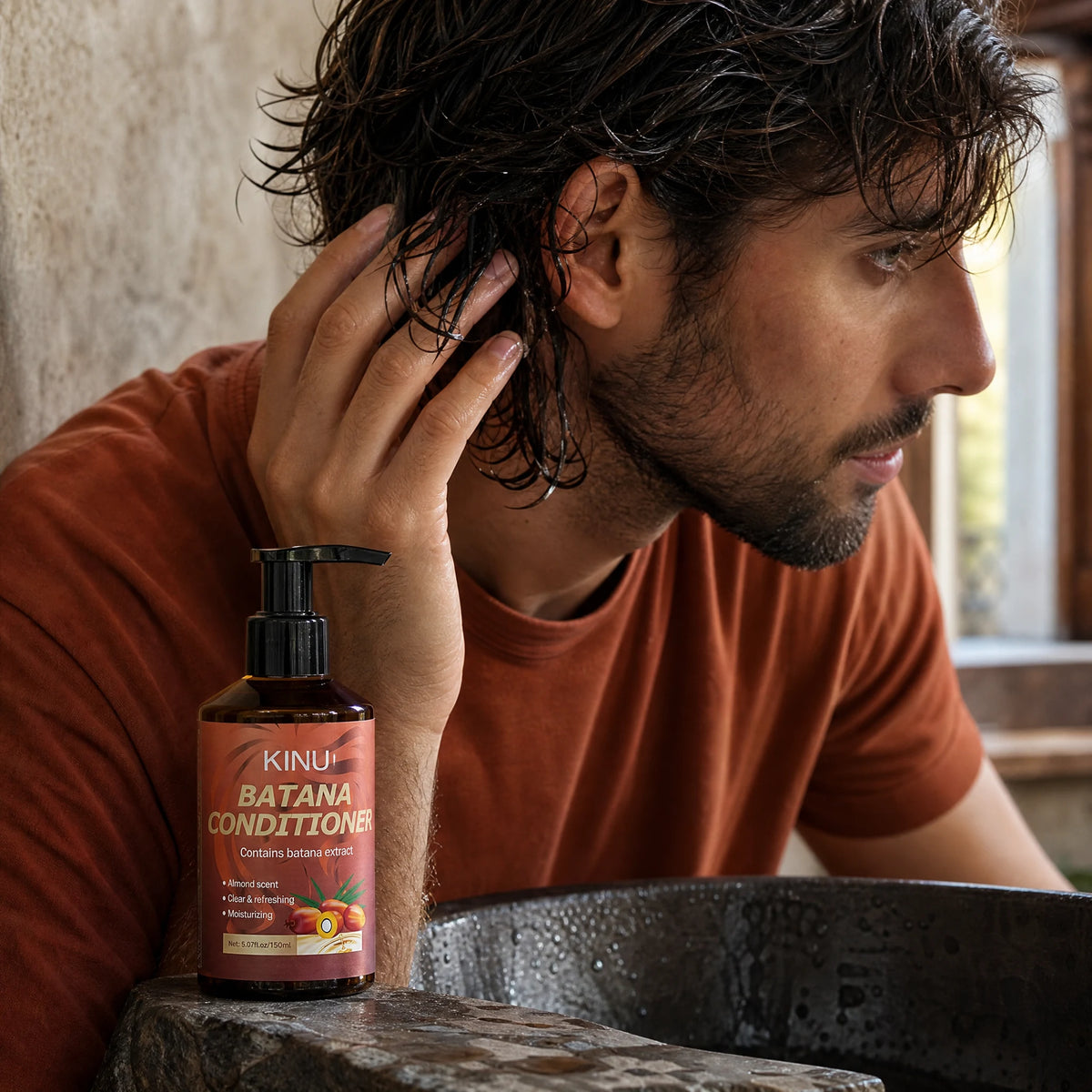An adult man working KINU conditioner through his hair