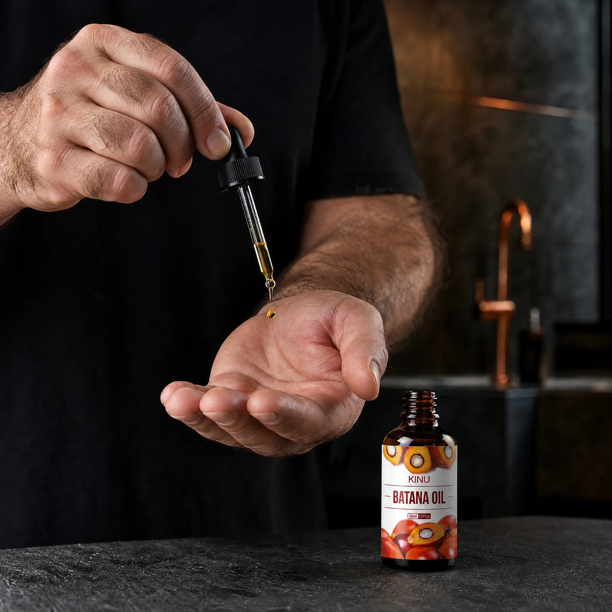 A man's hands dispensing KINU hair oil from its 30 ml dropper bottle