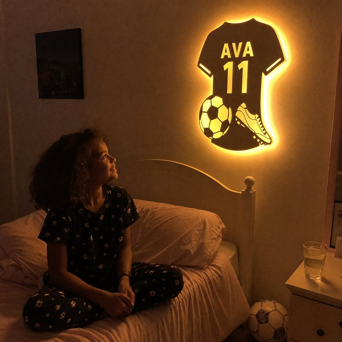Girl on her bed looking up at her glowing name jersey mirror
