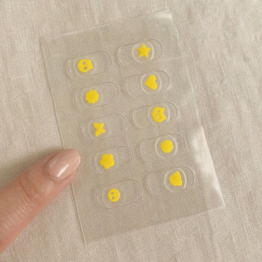 One NightCheck sheet with 10 clear nail stickers with yellow motifs