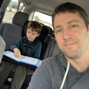 Sample reviewer photo: dad in the car, son reading on a travel tray