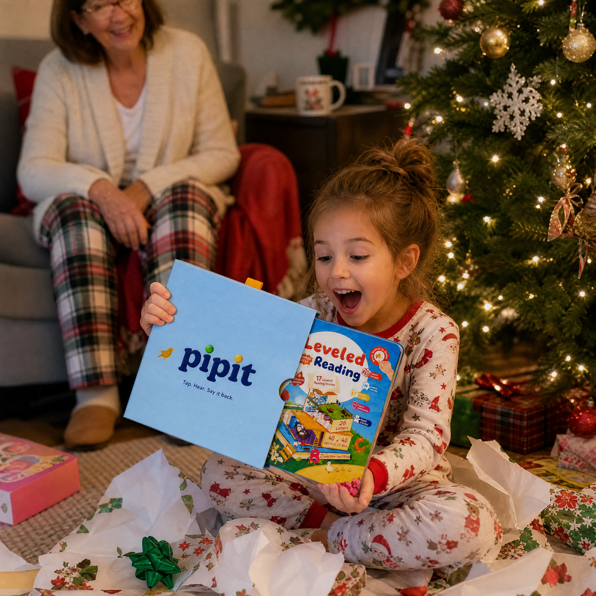 A girl unwrapping the Pipit Reader on Christmas morning