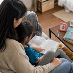 A parent and child share reading time with their visual timer nearby