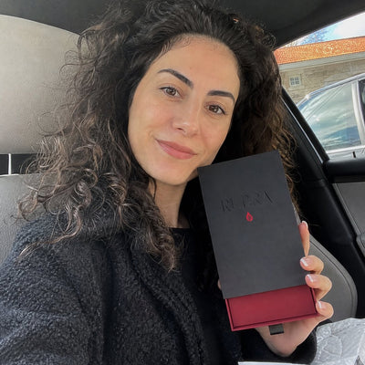 Sample reviewer holding the RUBRA box in her car