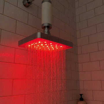 Inline filter above a glowing RUBRA head in a home shower