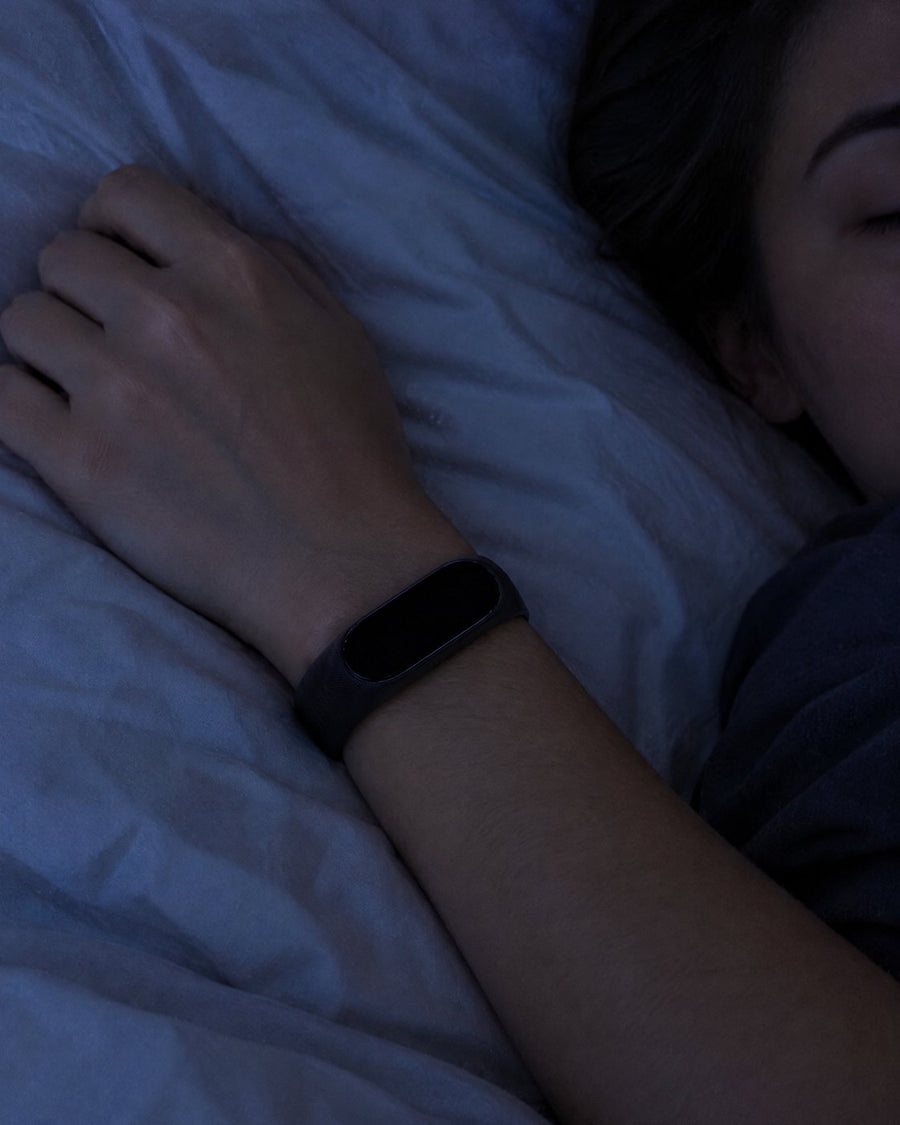 Wrist with a Rouse band resting on a pillow at night