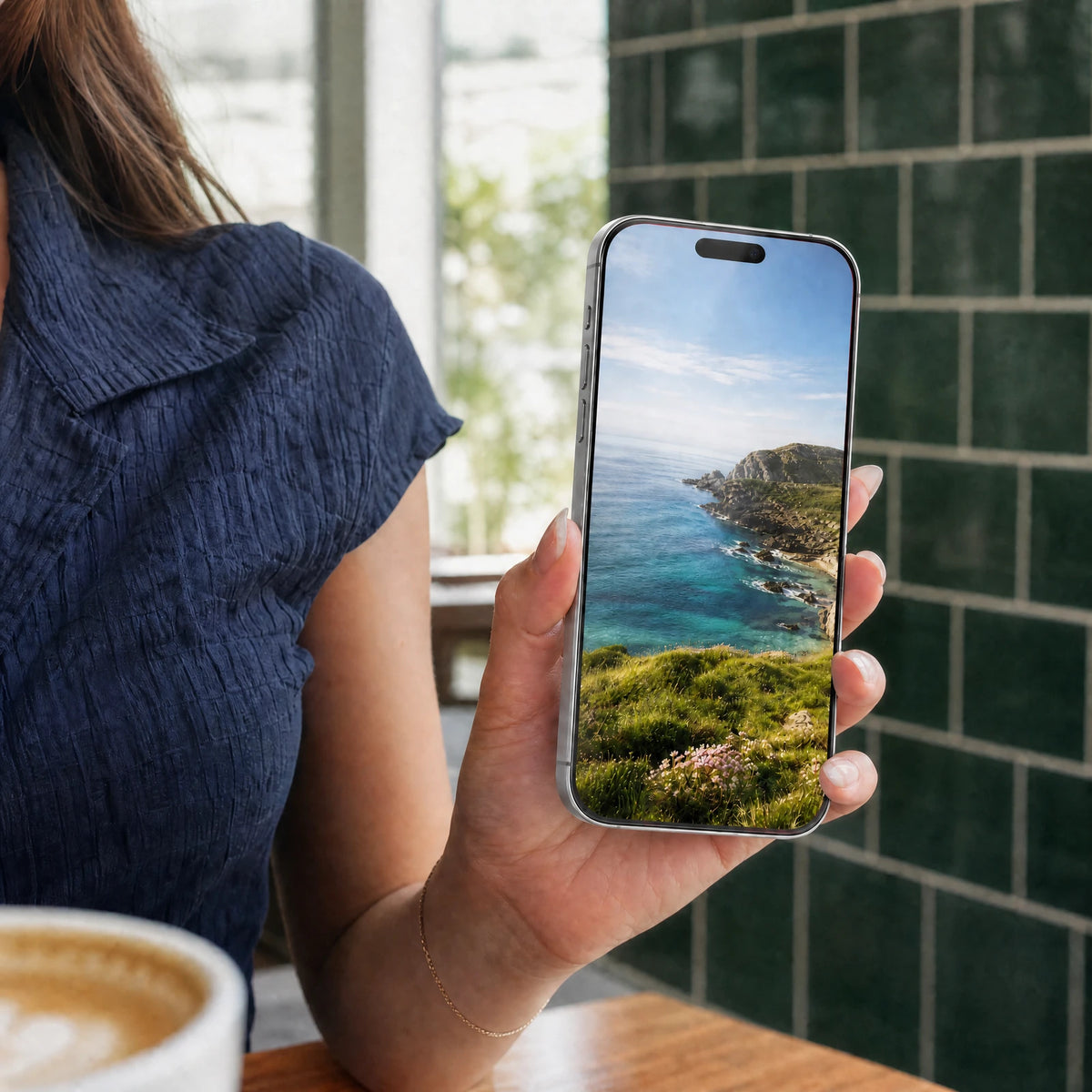 Everyday cafe use of a phone with a clear protector and a natural-color display; clear glass with a fine red edge.