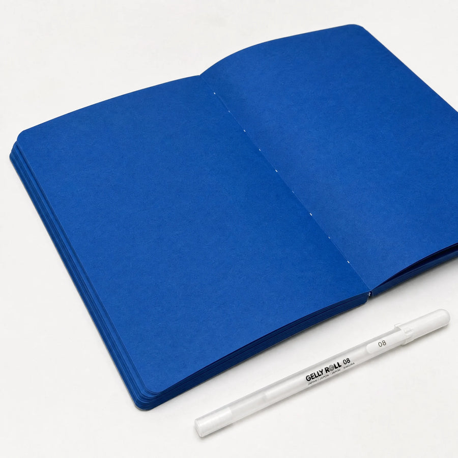 Lay-flat notebook with blue dyed paper and white gel pen
